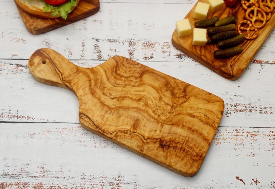 Olive wood cutting board with handle used for chopping vegetables